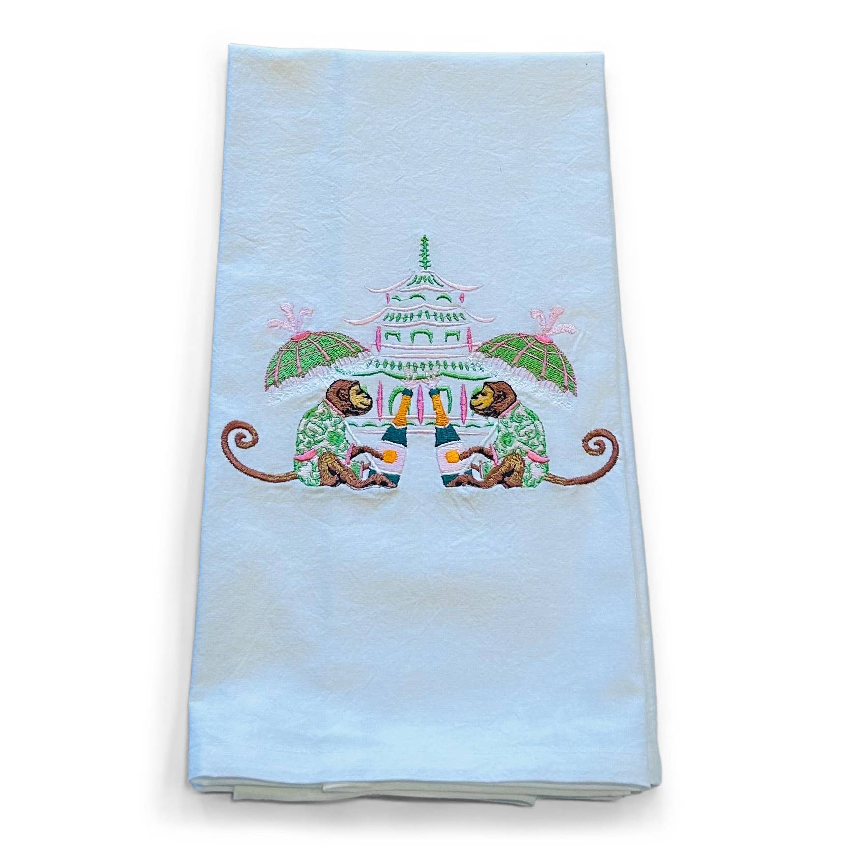 Embroidered towel with monkeys and pagoda design on a light blue background