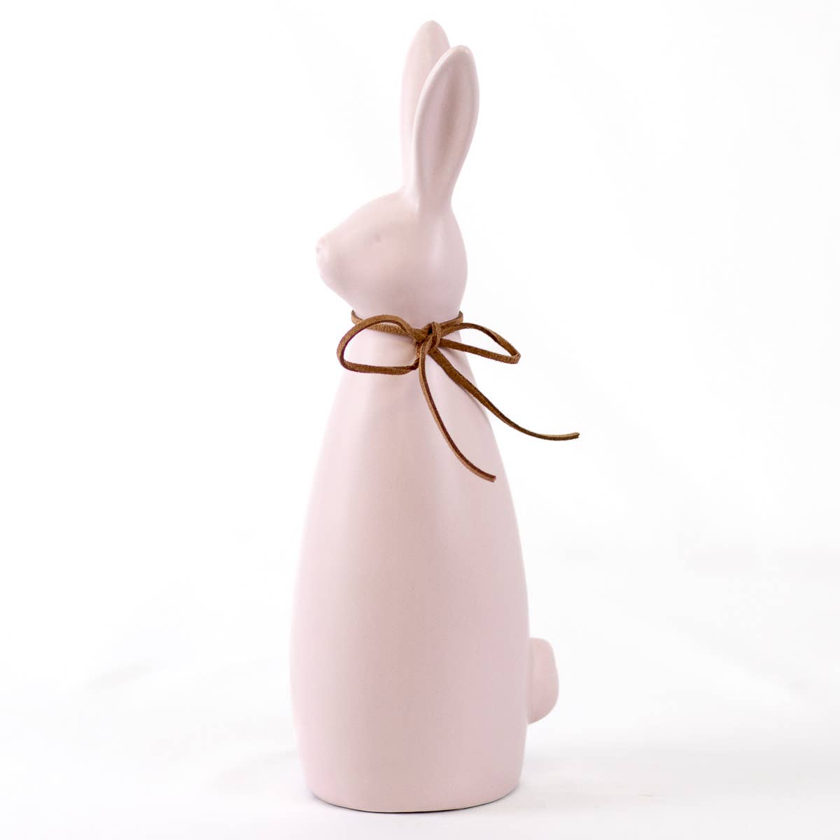 Pink ceramic bunny with a brown bow on a white background