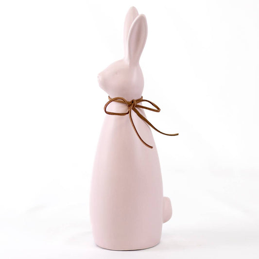 Pink ceramic bunny with a brown bow on a white background