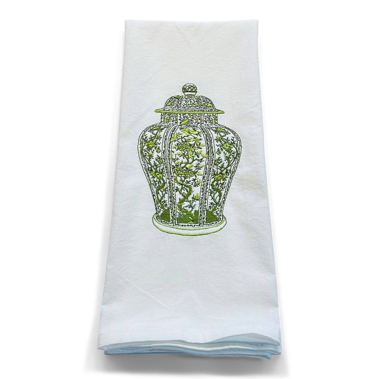 White towel with green decorative design on a white background