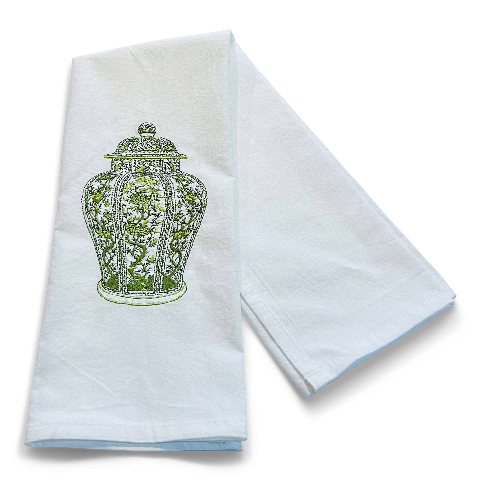 White towel with green decorative design on a white background